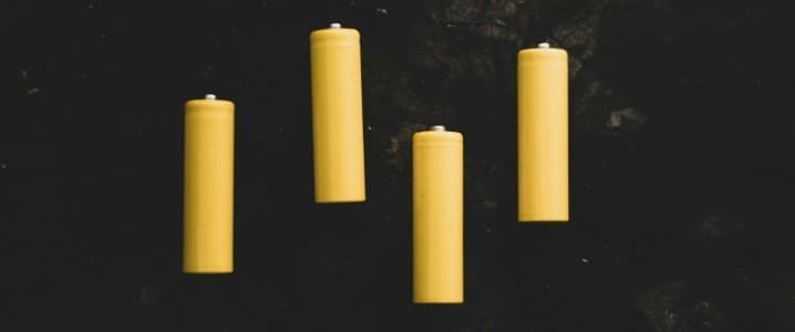 four yellow batteries on a black background