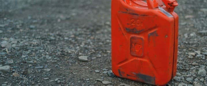 red gasoline can sitting on pavement